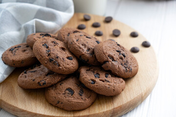 Homemade vegan cookies of oatmeal on wooden board with kitchen towel. Recipe of gluten free cookies with raisins, vegan diet dessert. Snack or treat for tea or coffee.