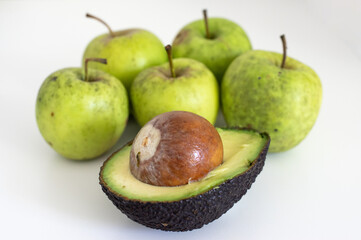  an avocado and green apples on white