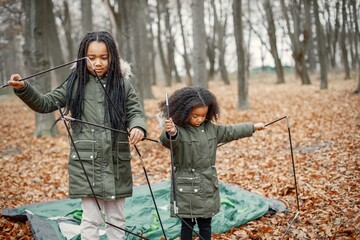 Two little black sisters in tent camping in the autumn forest © prostooleh