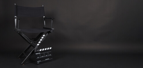 Black Director chair and black clapper board or movie slate on black blackground.