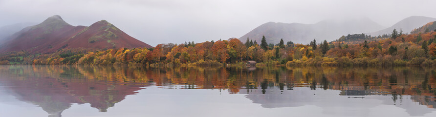 Fototapeta na wymiar Stunning landscape image of Catbells viewed acros Derwentwater during Autumn in Lake District with mist rolling across the hills and woodland
