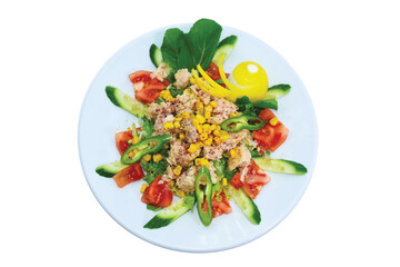 Overhead view of tuna fish salad with tomatoes, arugula, corn served on white plate
