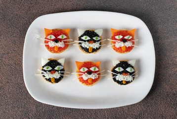 Tartlets Kittens with cheese, egg and caviar on white plate on brown table, Top view