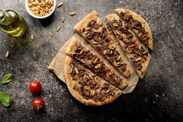 lahm bi ajeen pizza slice with nuts and tomato isolated on cutting board top view fastfood