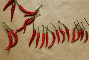 Chili pepper on craft paper background. Top view photo of red peppers on table in a random position