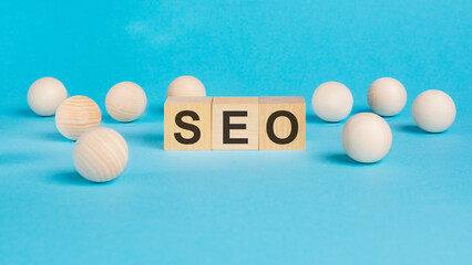 business concept. on the blue table wooden balls and wooden cubes with the inscription - SEO -...
