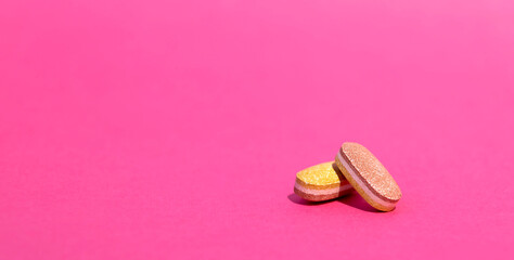 Pharmaceutical tablets, pills, capsules. Two colorful pills on a pink background. Concept of medicine. virus protection. Selected focus