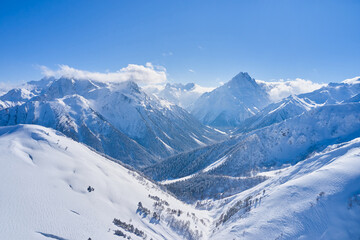 Aerial view of mountains snow in Russia on a sunny day