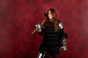 History of the Middle Ages. Portrait of a beautiful medieval female knight in armour on a red background..