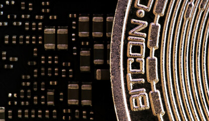 Macro photograph of a bitcoin coin next to electronic circuits