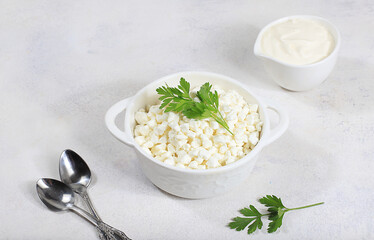 Cup with natural curd cheese and greens,healthy breakfast with ingredients,served with sour cream or sauce,healthy natural products with probiotic,helping to lose weight,selective focus,