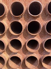 A group of arranged pipe ends of a rusted vessel