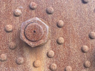 Fototapeta na wymiar Rusted screws and rivets on a rusty metal plate