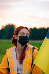 Portrait of a beautiful Ukrainian girl in glasses and a black mask. Pandemic. Girl with the flag of Ukraine