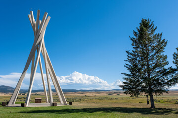 Cement teepee and a tree at a South Dakota rest stop on a sunny, summer day.