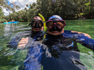 A couple snorkeling having fun in clear water taking a selfie.