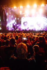 Using a smartphone in a public event, live music festival.  Summer holiday, vacation concept. 