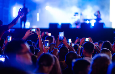 Using a smartphone in a public event, live music festival.  Summer holiday, vacation concept.  - obrazy, fototapety, plakaty