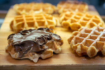 Waffles are fresh for breakfast and chocolate spread is spread on one waffle