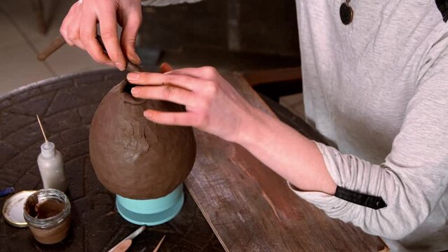 Woman Potter in apron holds clay in her hands and kneads it. High quality 4k footage