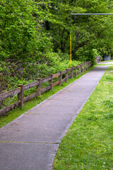 Short wooden fence between woodlands and sidewalk