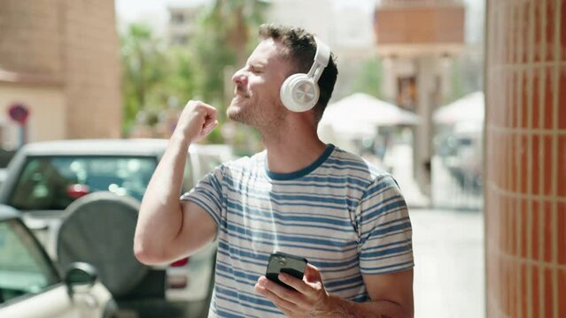 Young Hispanic Man Listening To Music And Dancing At Street