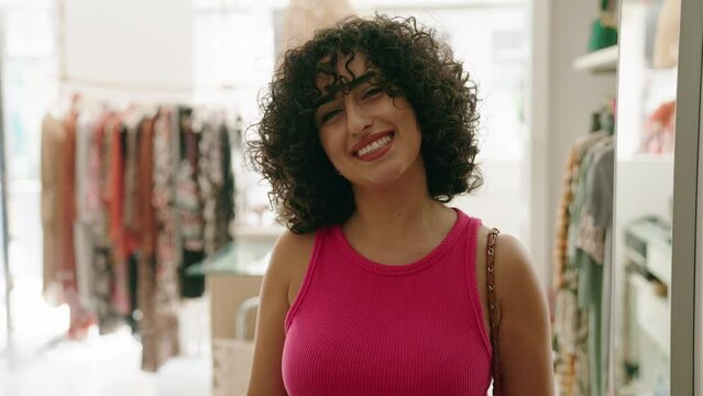 Young middle eastern woman customer smiling confident standing at clothing store
