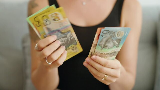 Young woman counting australia dollars banknotes at home