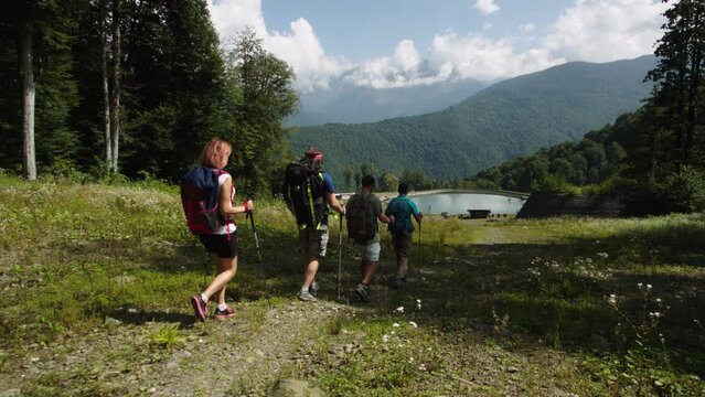 Group of hikers walking on a mountain at autumn day. People go down to resort for respiratory treatment. Camping, weekends, health improvement. Getting rid of excess weight