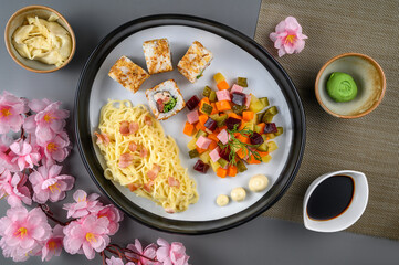 Japanese dish of rolls, salad and pasta on a plate