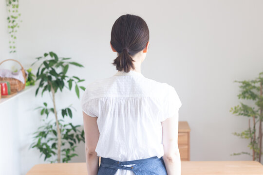 エプロンを着た女性の後ろ姿