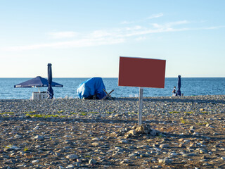 Blank sign on the beach. Mocap. Place for an inscription on the seashore. End of the season. On the...