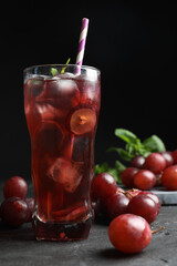 Delicious grape soda water on black table. Refreshing drink