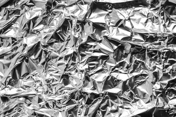 Crumpled silver foil as background, top view