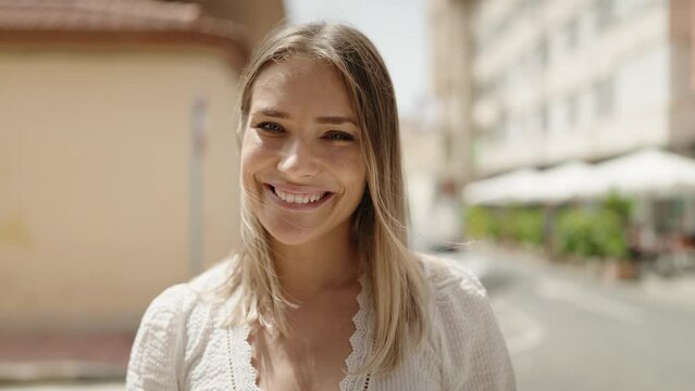 Young caucasian woman smiling confident standing at street