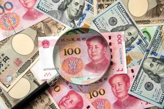 Kkey currency image -US Dollar, JP Yen, Eurp and Chinese Yen with magnifying glass.