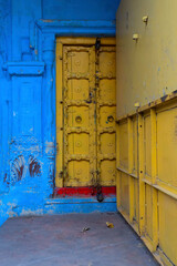 Traditional yellow wooden door and blue coloured house of Jodhpur city, Rajsthan, India. Historically, Hindu Brahmins used to paint their houses in blue for being upper caste, the tradition follows.