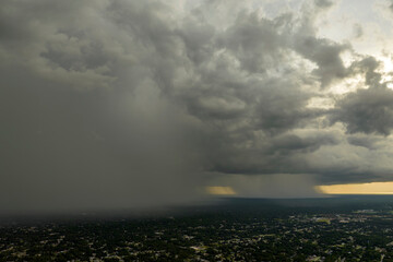 Landscape of dark ominous clouds forming on stormy sky during heavy thunderstorm over rural town area