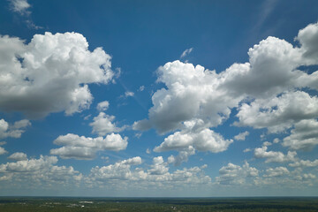 White puffy cumulus clouds on summer blue sky