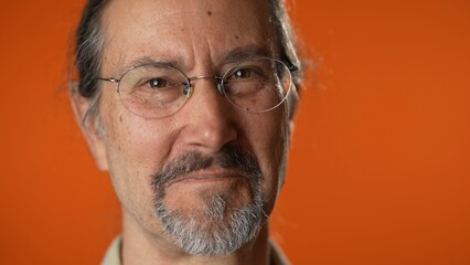 Closeup portrait of smiling happy mature man on isolated on solid orange background.