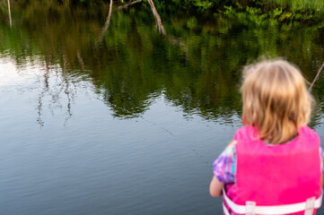 girl fishing with blue water in background