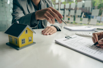 Fototapeta premium Home agents talk to new home buyers and offer good interest rates and calculate clients on mortgage financing to help make real estate concept decisions.