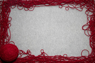 top view of crocheted gray background with red yarn border with a place for text, for yarn and...