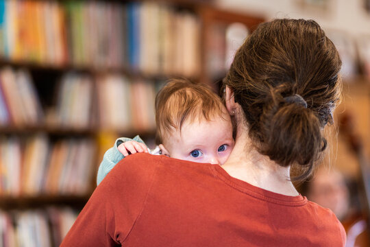 blue baby eyes looking over woman's shoulder