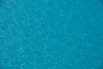 Background of blue water in swimming pool with sun reflection, ripple water wave in pool. Clear water background.