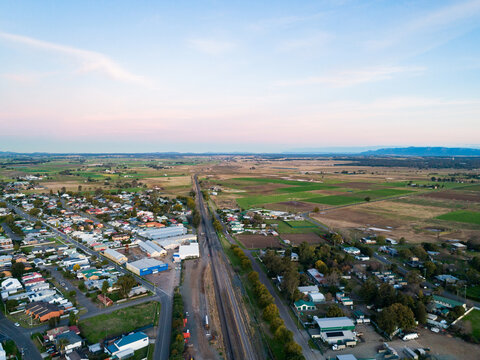 Train track at edge of town with farm paddocks and dusk sky