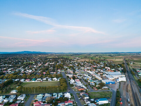 park and train tracks surrounded by buildings in town at dusk