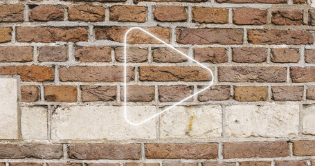 Image of glowing neon arrow icon on brick wall