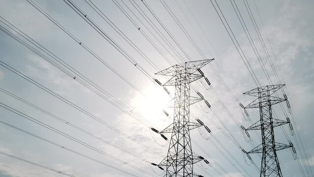 A timelapse footage with noise effect electic transmission tower with moving cloud and sun insight. Electric and energy concept.