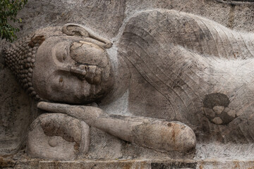 Fototapeta na wymiar A reclining Buddha represents Buddha lying down, represents the historical Buddha during his last illness, about to enter the parinirvana 